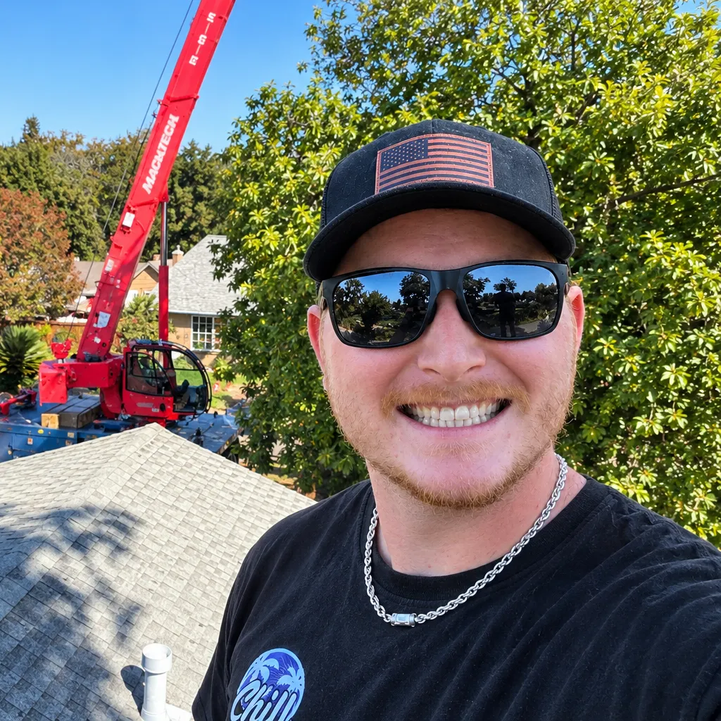 Cameron Hill on a rooftop jobsite with a crane behind him