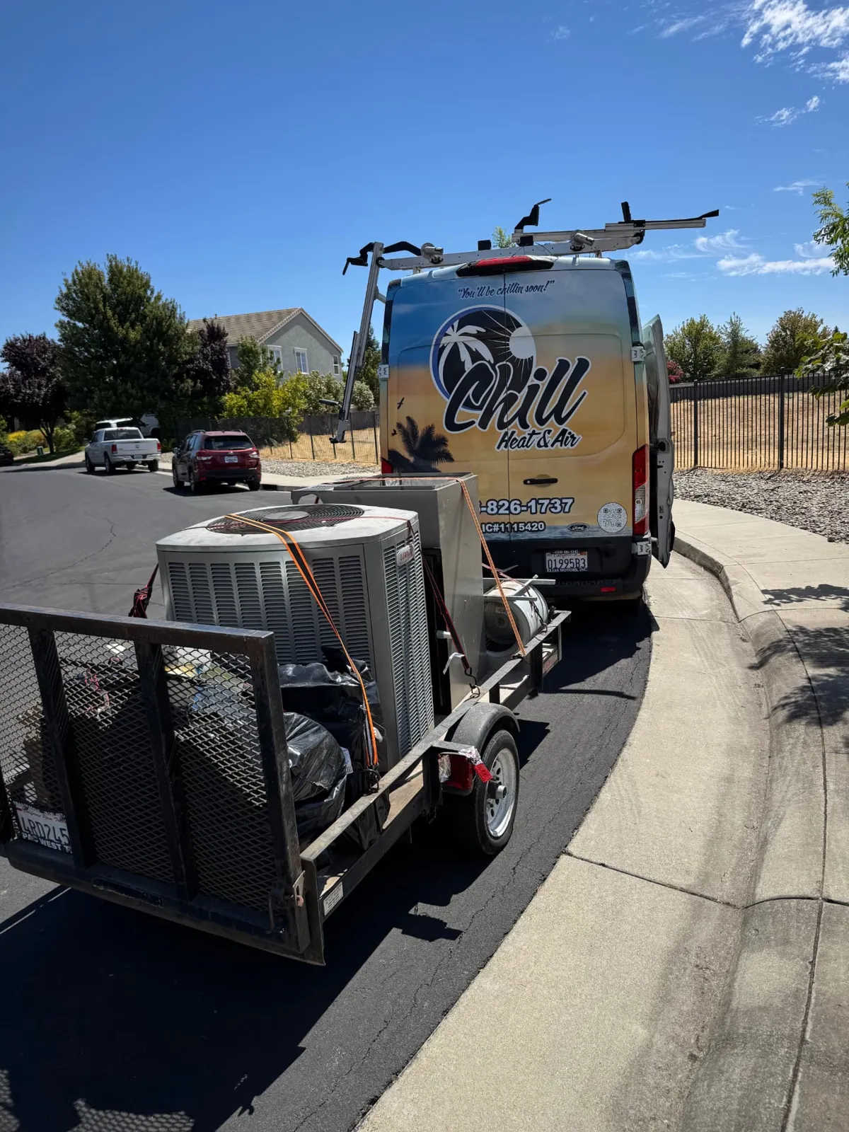 Trailer loaded with old air conditioning equipment beside the Chill van